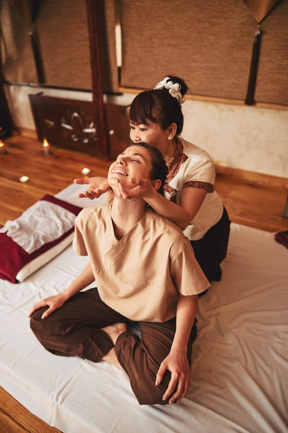 Client receiving a soothing neck stretch from a Thai massage therapist